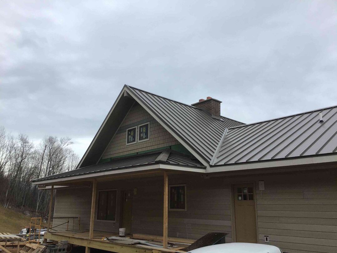 a house under construction with a metal roof and a porch .
