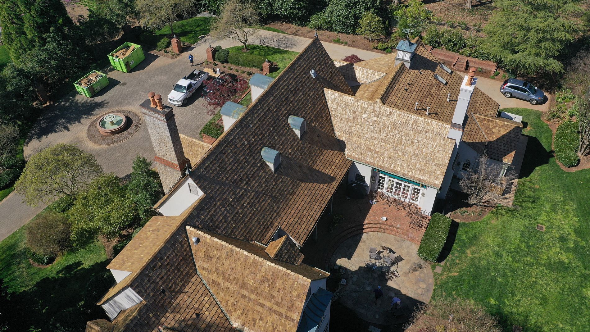 An aerial view of a large house with a lot of trees in the background