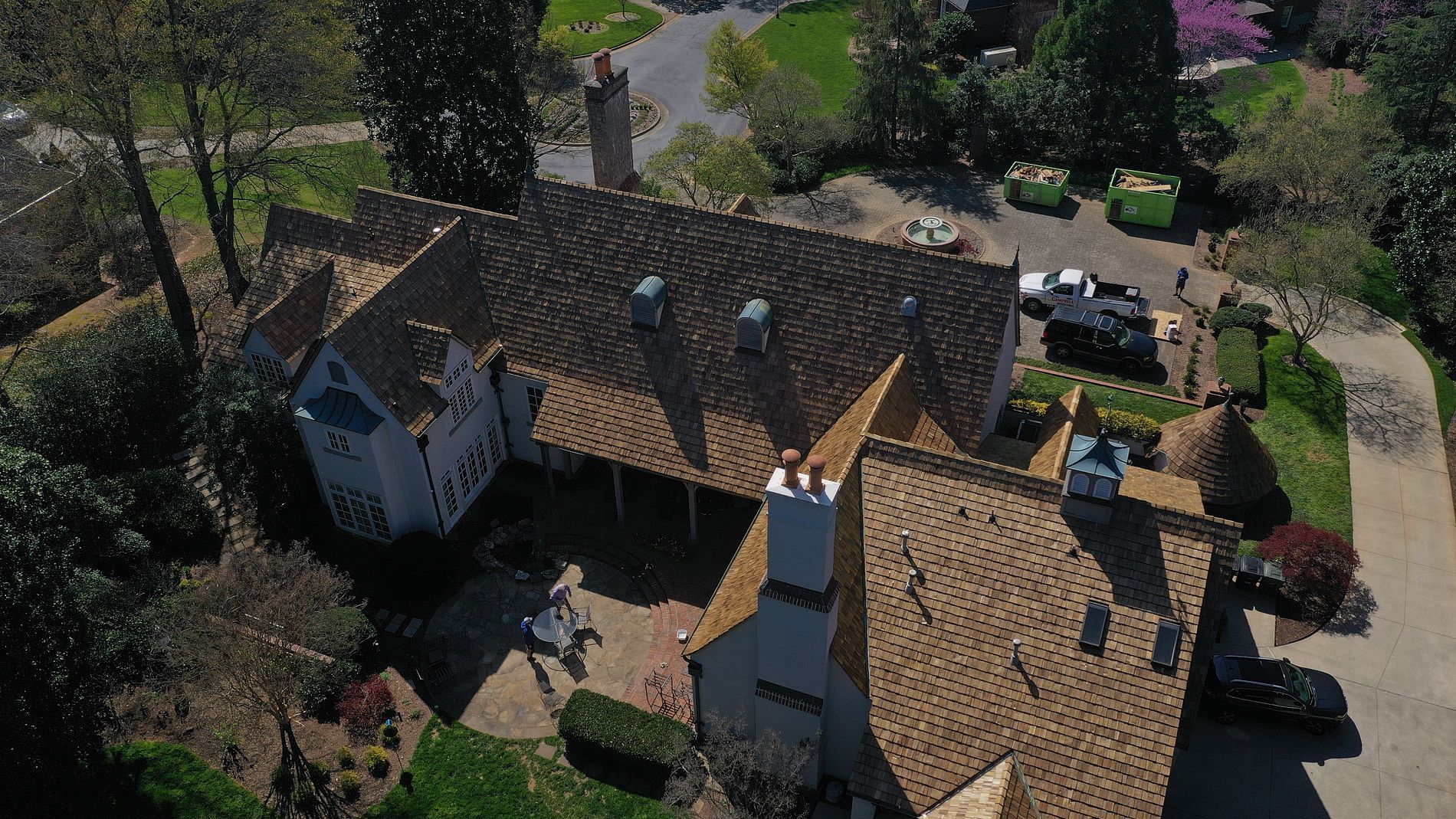 An aerial view of a large white house with a brown roof