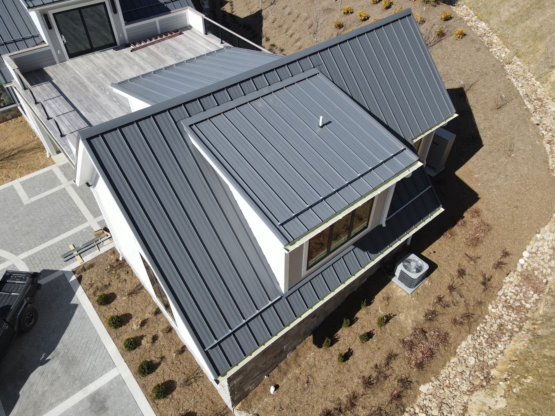 An aerial view of a house with a gray roof