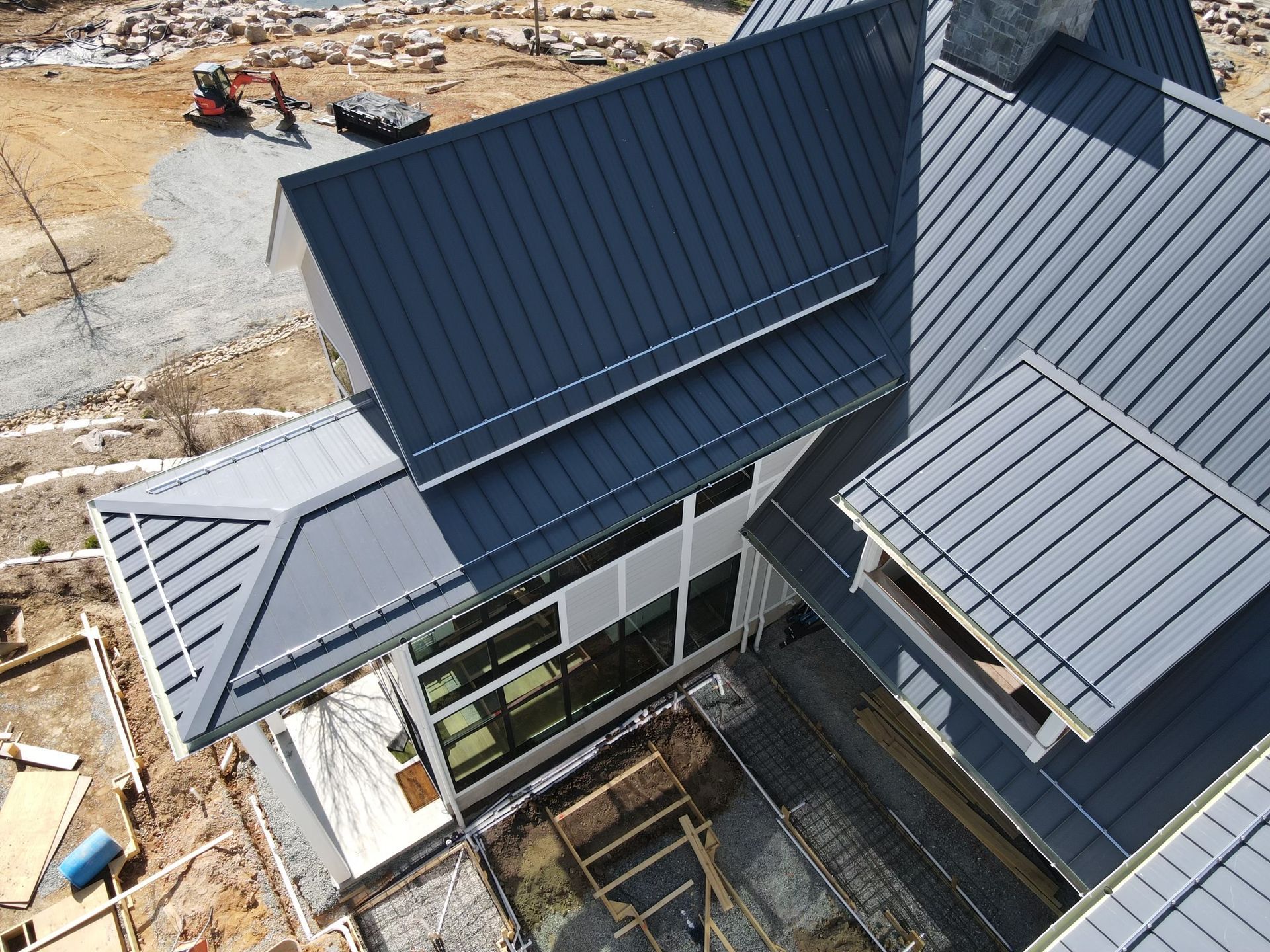 An aerial view of a house under construction with a metal roof.