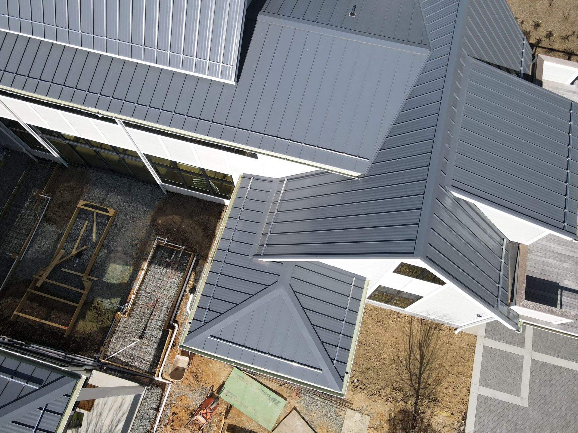 An aerial view of a house under construction with a gray roof.