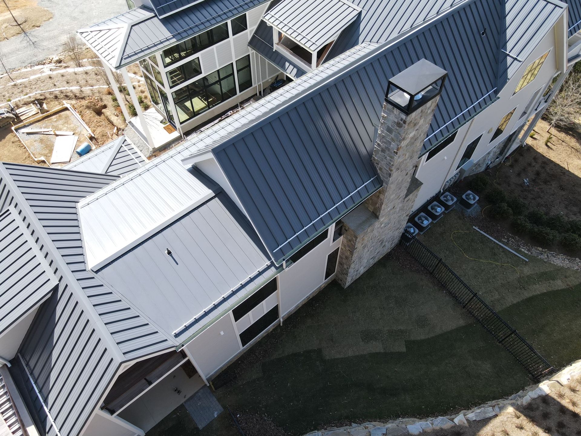 An aerial view of a large white house with a blue roof.