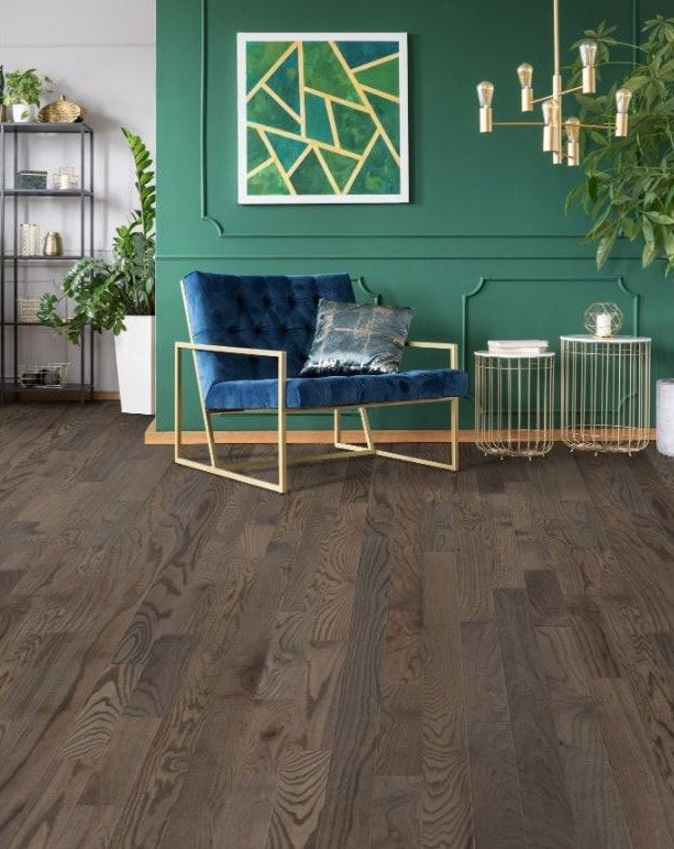 A living room with a blue chair and a green wall.