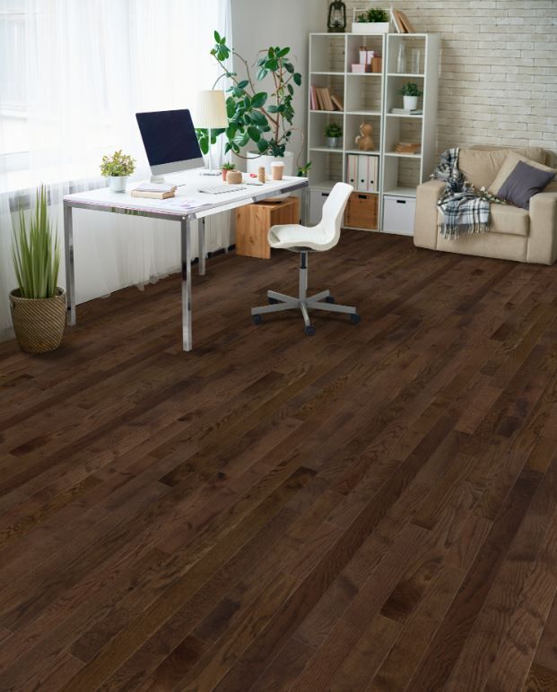 A living room with hardwood floors and a desk with a computer on it