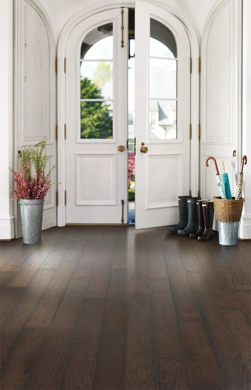 A hallway with a wooden floor and a white door.
