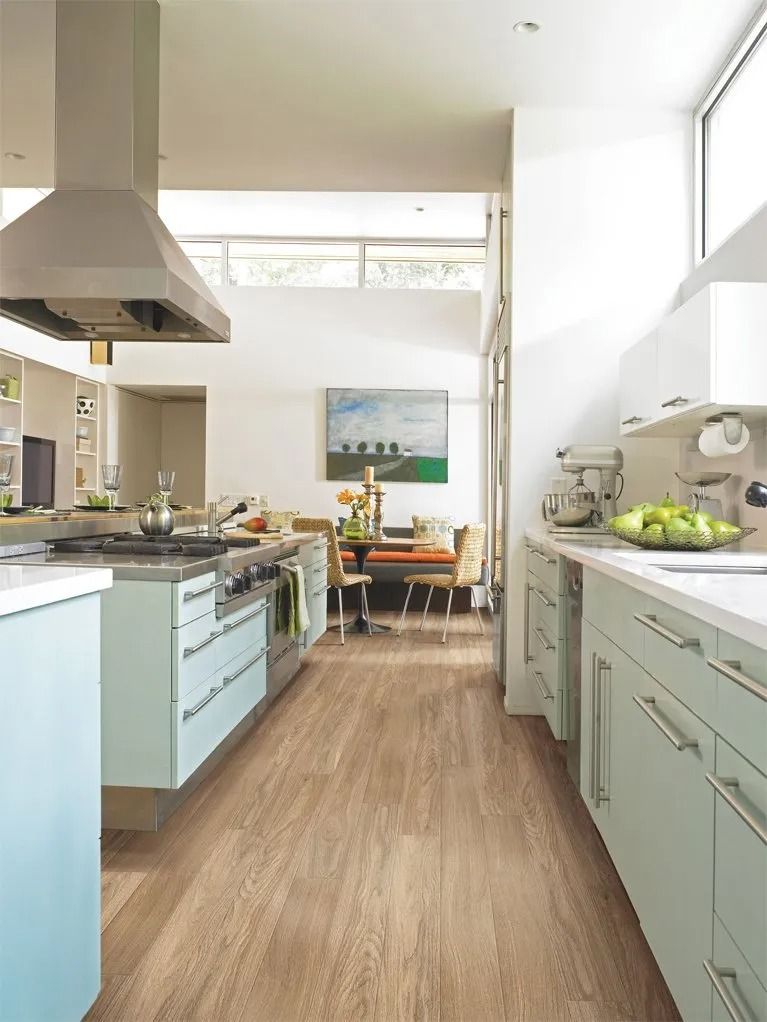 A kitchen with a wooden floor and white cabinets