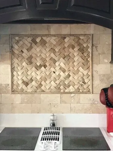 A man is standing in front of a stove in a kitchen.