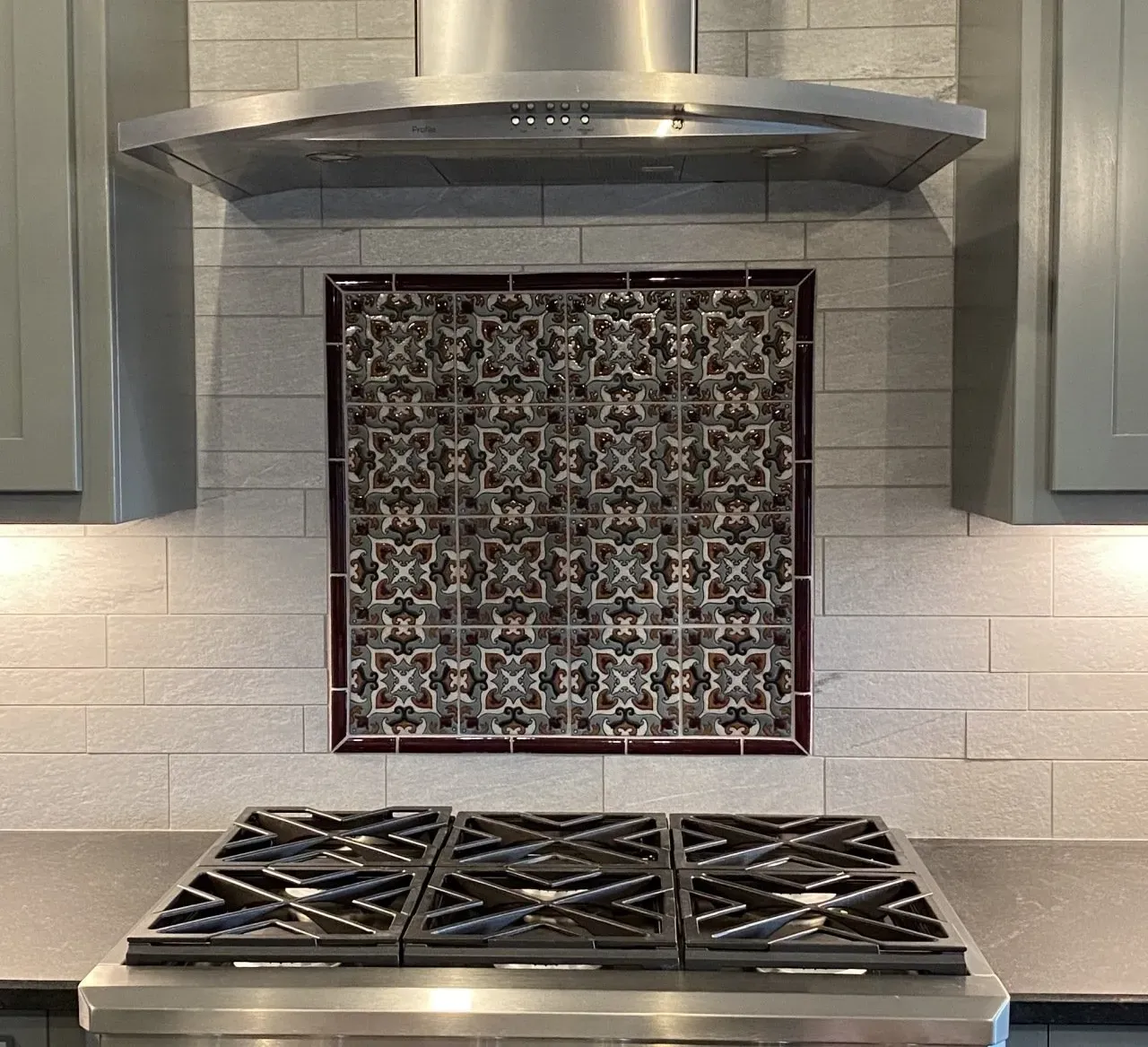 A kitchen with a stove top oven and a hood above it