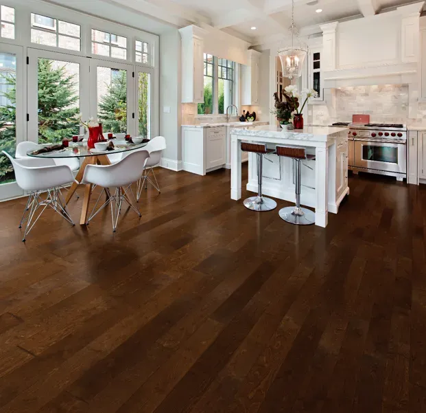 A kitchen with hardwood floors and a table and chairs