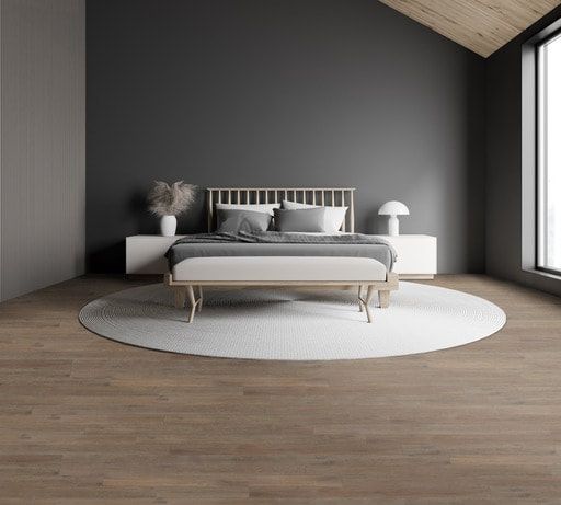 A bedroom with a bed , nightstands , a rug and a window.