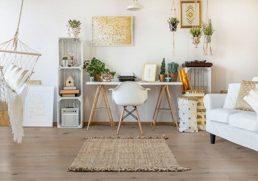 A living room with a desk , chair , couch and hammock.