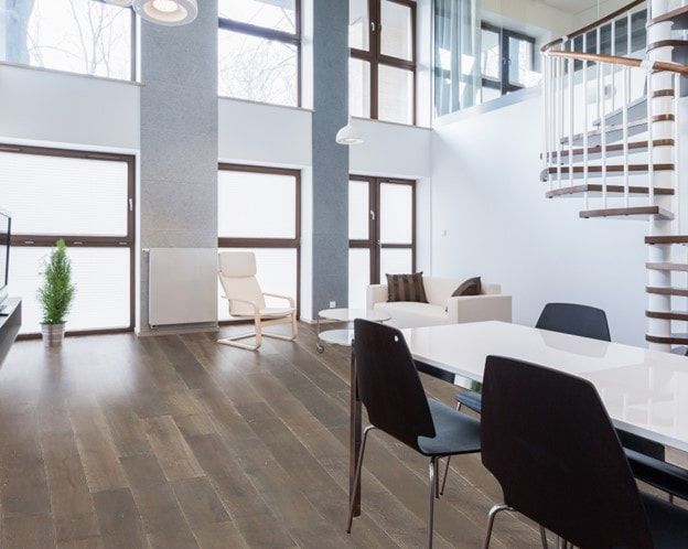 A living room with a table and chairs and a spiral staircase