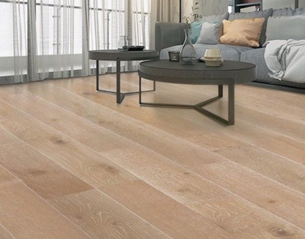 A living room with hardwood floors and a couch and two coffee tables.