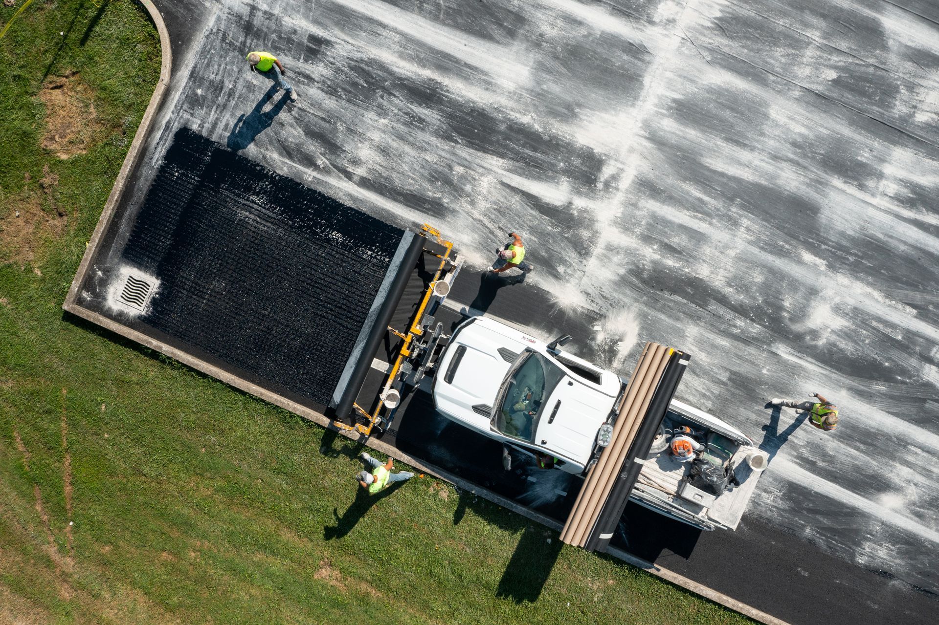 an aerial view of a truck being loaded with asphalt