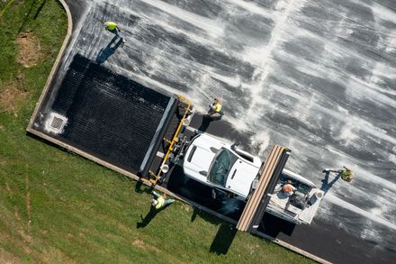 an aerial view of a truck being loaded with asphalt