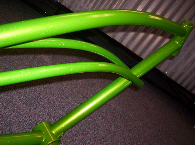 A green pipe is sitting on a carpeted floor