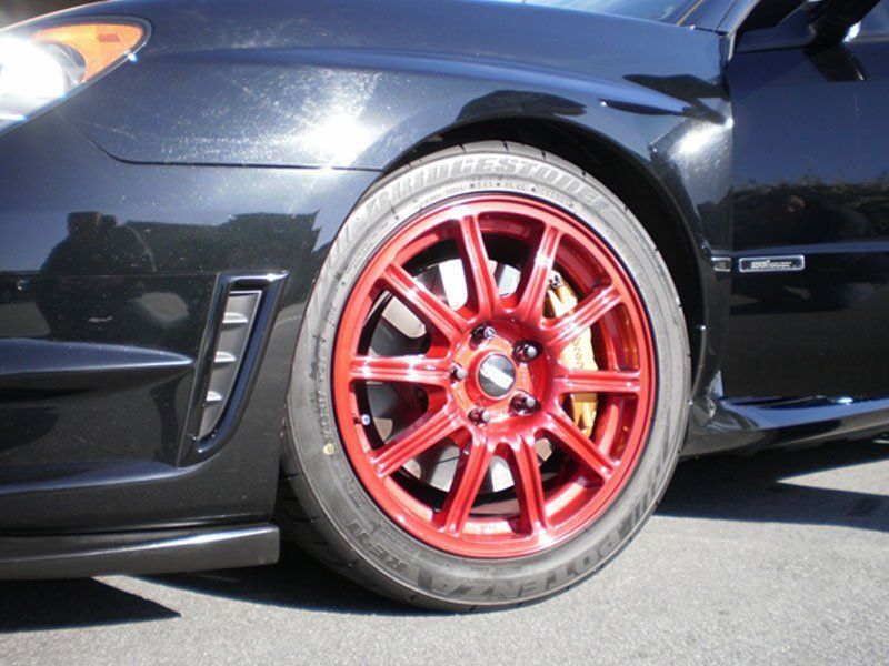 A black car with red wheels and tires