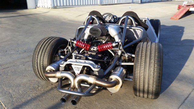 A car with a large engine is parked in a parking lot