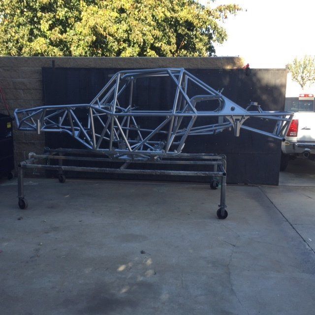A large metal frame is sitting on a cart in a parking lot