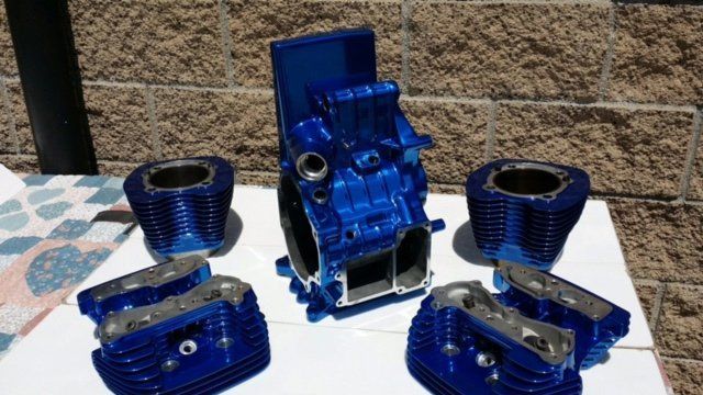 A blue motorcycle engine is sitting on top of a white table.