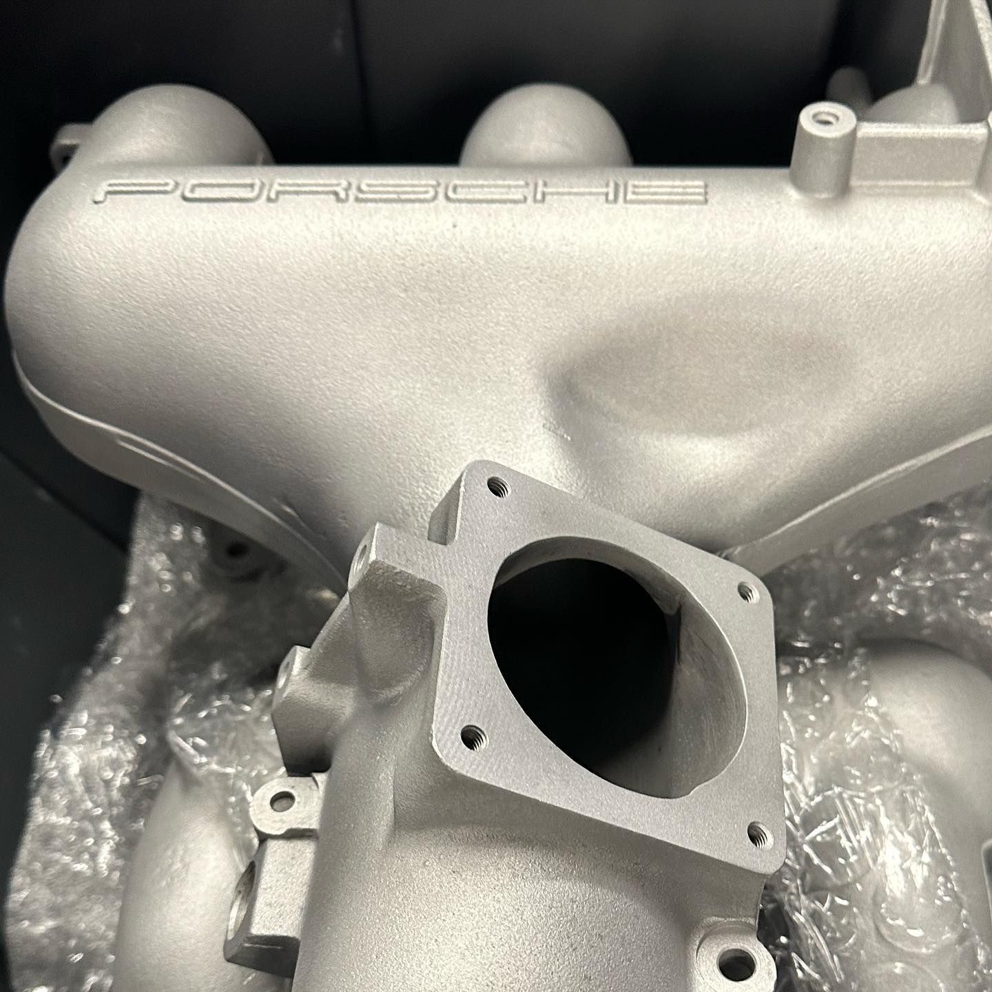 A close up of a porsche engine intake manifold