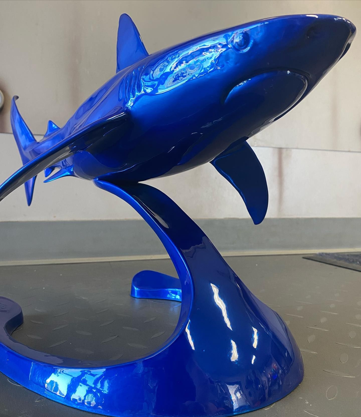 A blue shark statue is sitting on a blue base