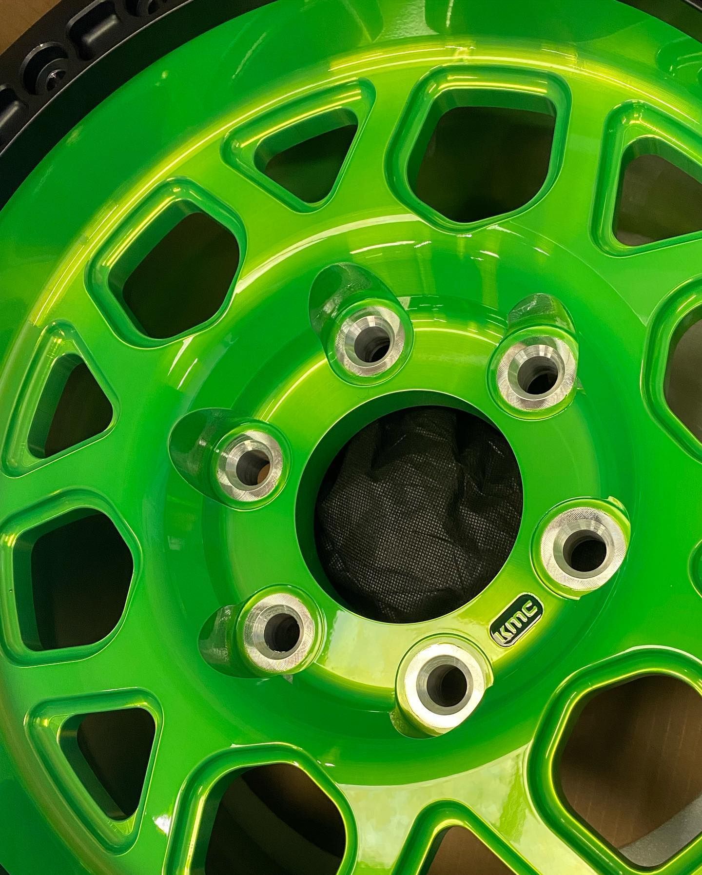 A close up of a green wheel with holes in it