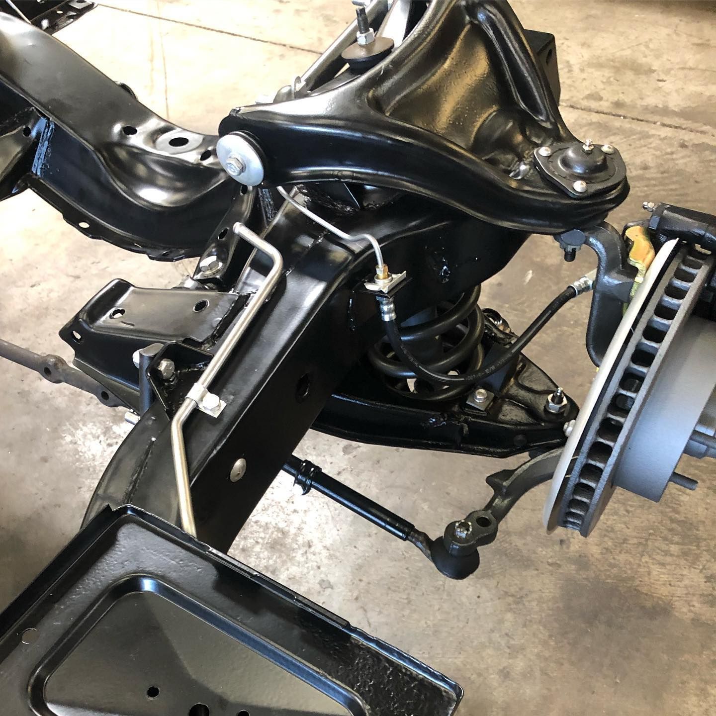 A close up of a car chassis with a brake disc on it.