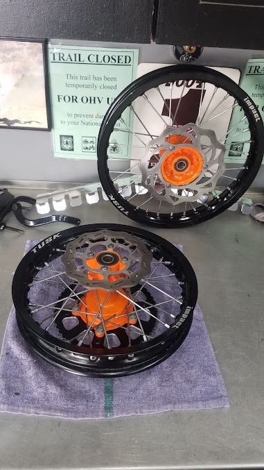 Two motorcycle wheels are sitting on a towel on a table.