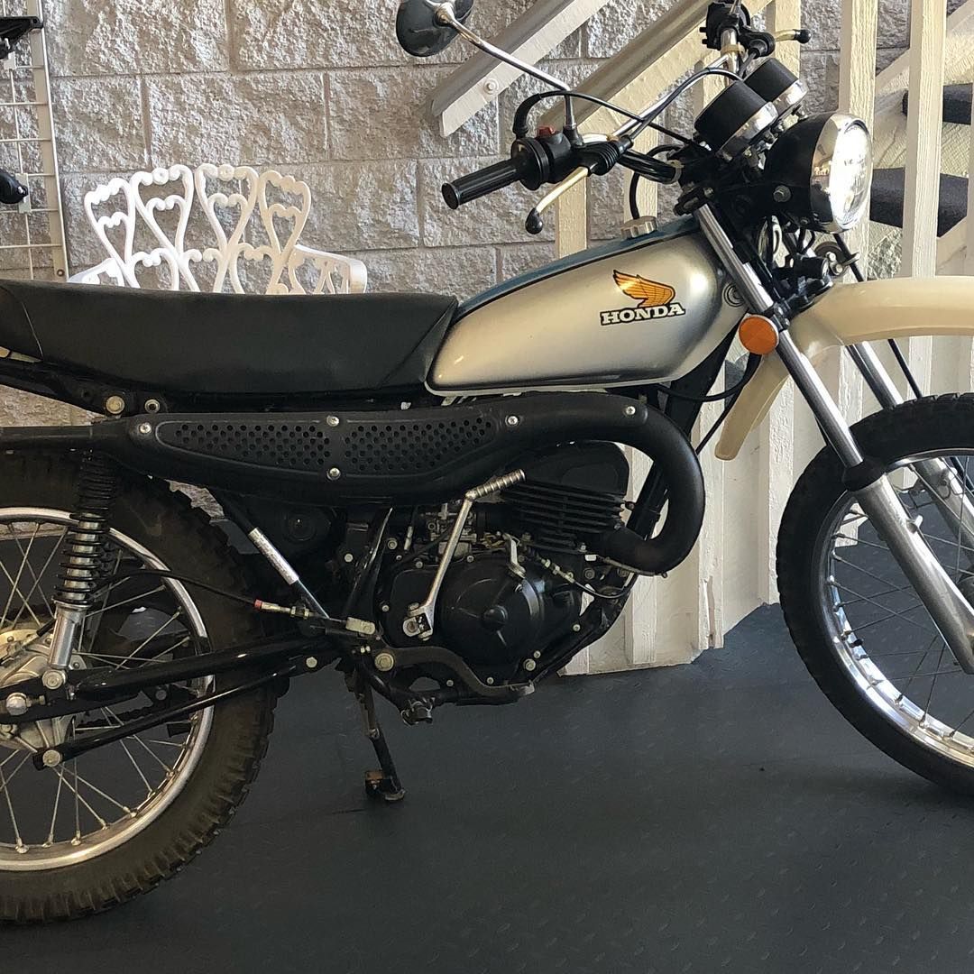 A honda dirt bike is parked in front of a staircase