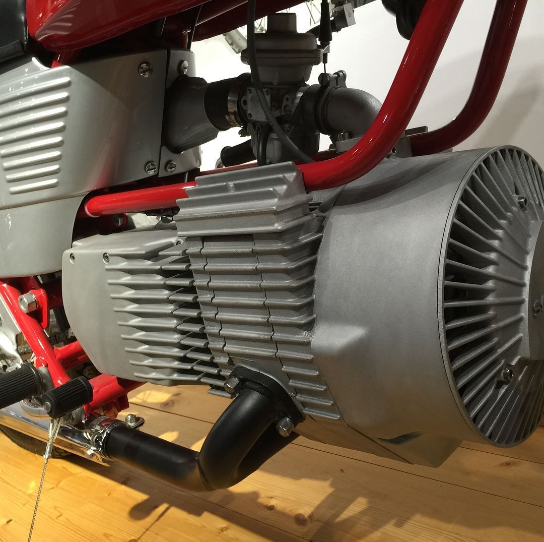 A close up of a motorcycle engine on a wooden floor