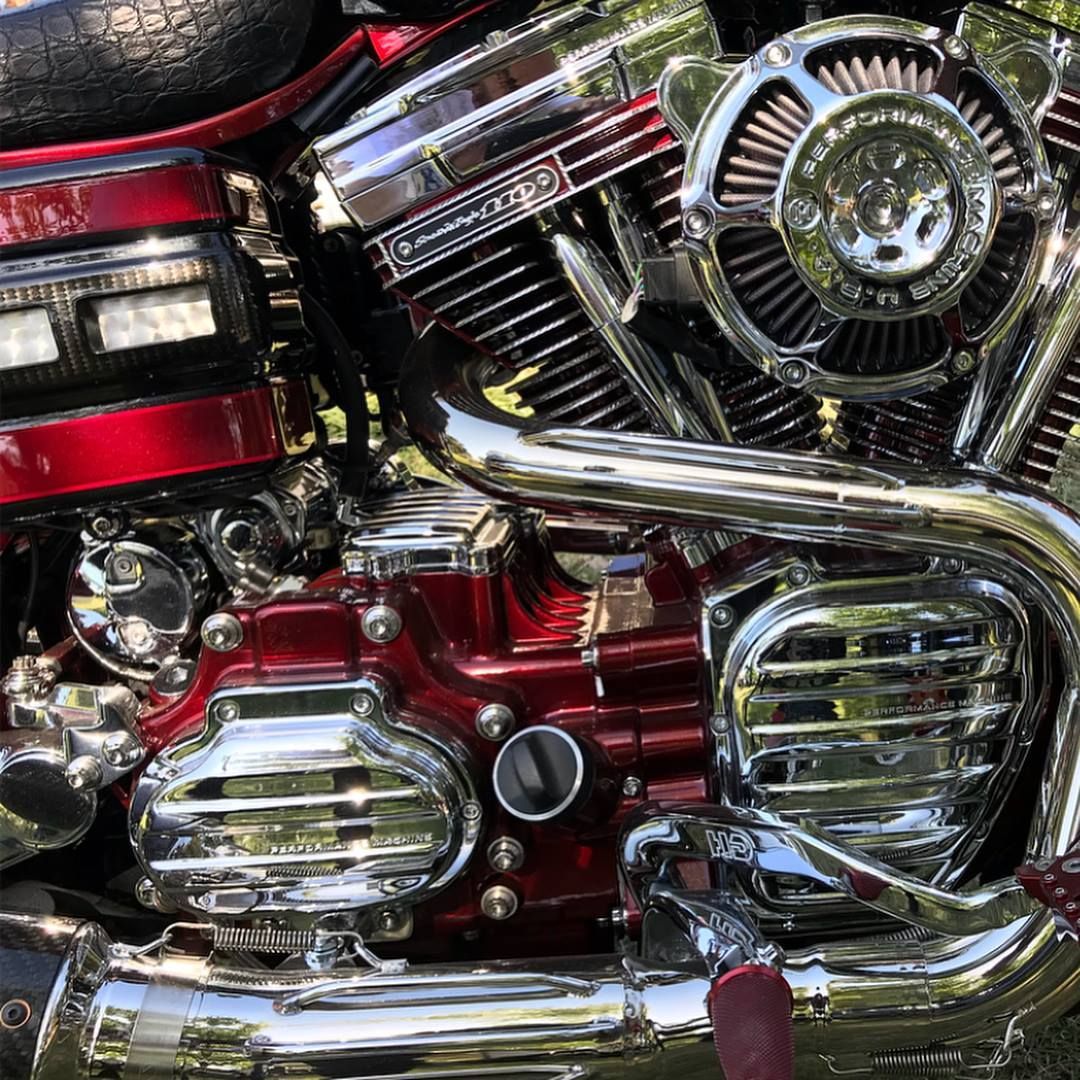 A close up of the engine of a red and chrome motorcycle.