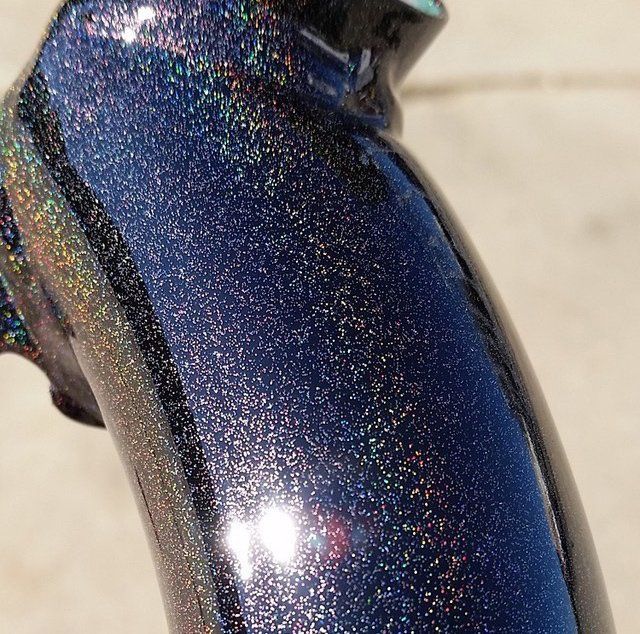 A close up of a blue and black object with glitter on it.