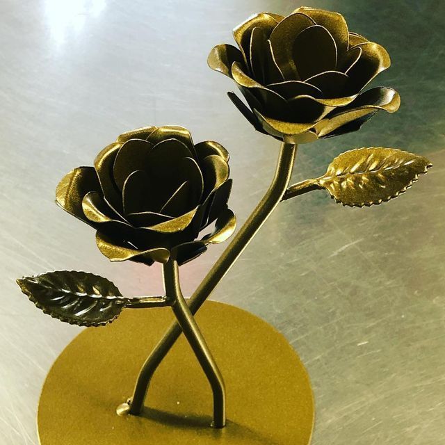 A metal sculpture of two roses with leaves
