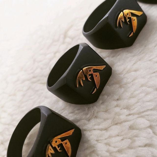 Three black rings with gold letters on them