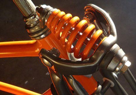 A close up of a bicycle fork with orange springs