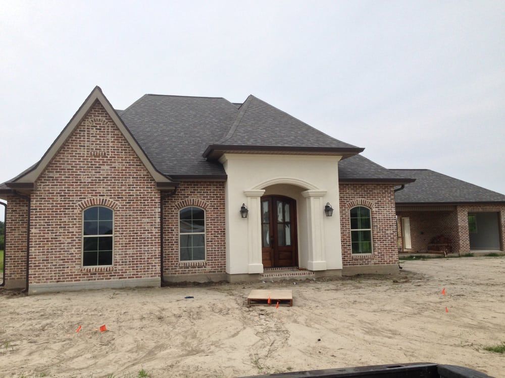 A brick house with a gray roof is being built