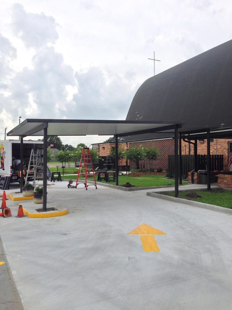 A parking lot with a canopy over it and a yellow arrow pointing to the right.