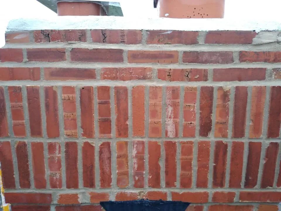 Close-up of a red brick wall with decorative vertical brick pattern and white mortar.