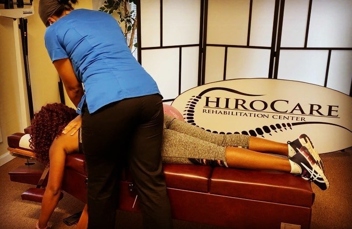 Therapist adjusting a patient on a treatment table in a rehabilitation center
