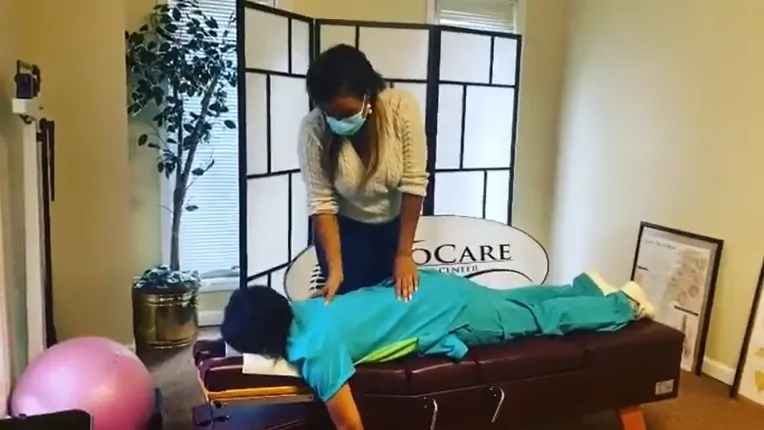 Massage therapist working on a client on a table in a spa room