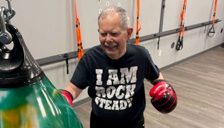 elderly man punching a punching bag