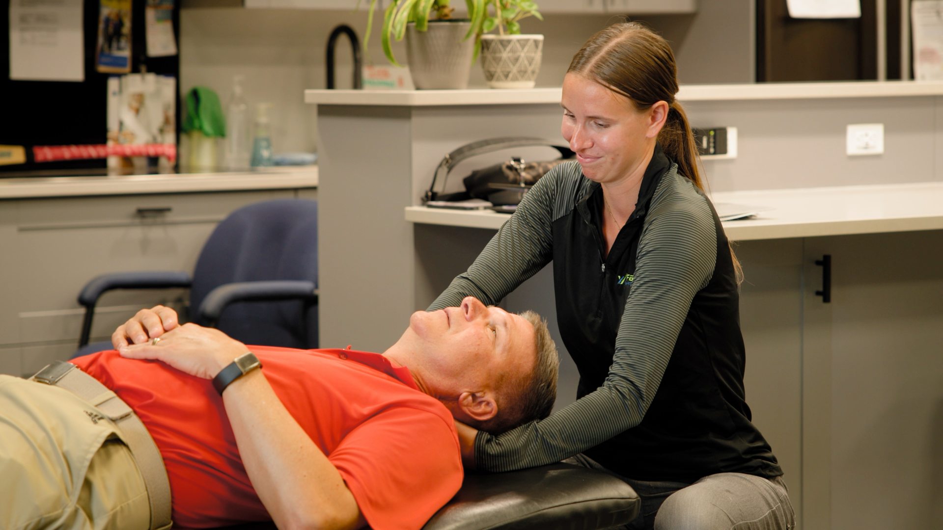 A woman is giving a man a massage on a table.