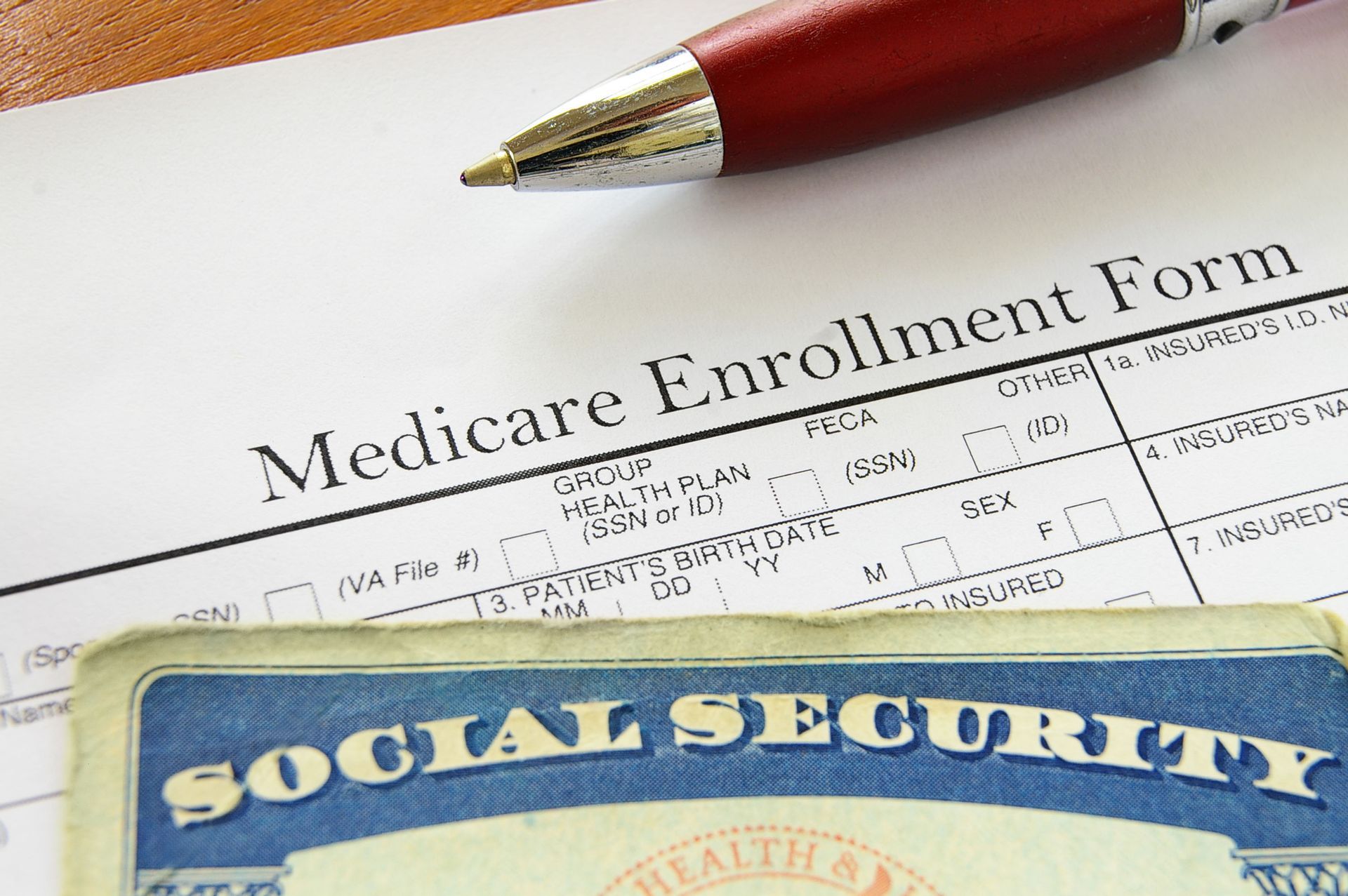 Medicare Enrollment Form with a Social Security card and pen.