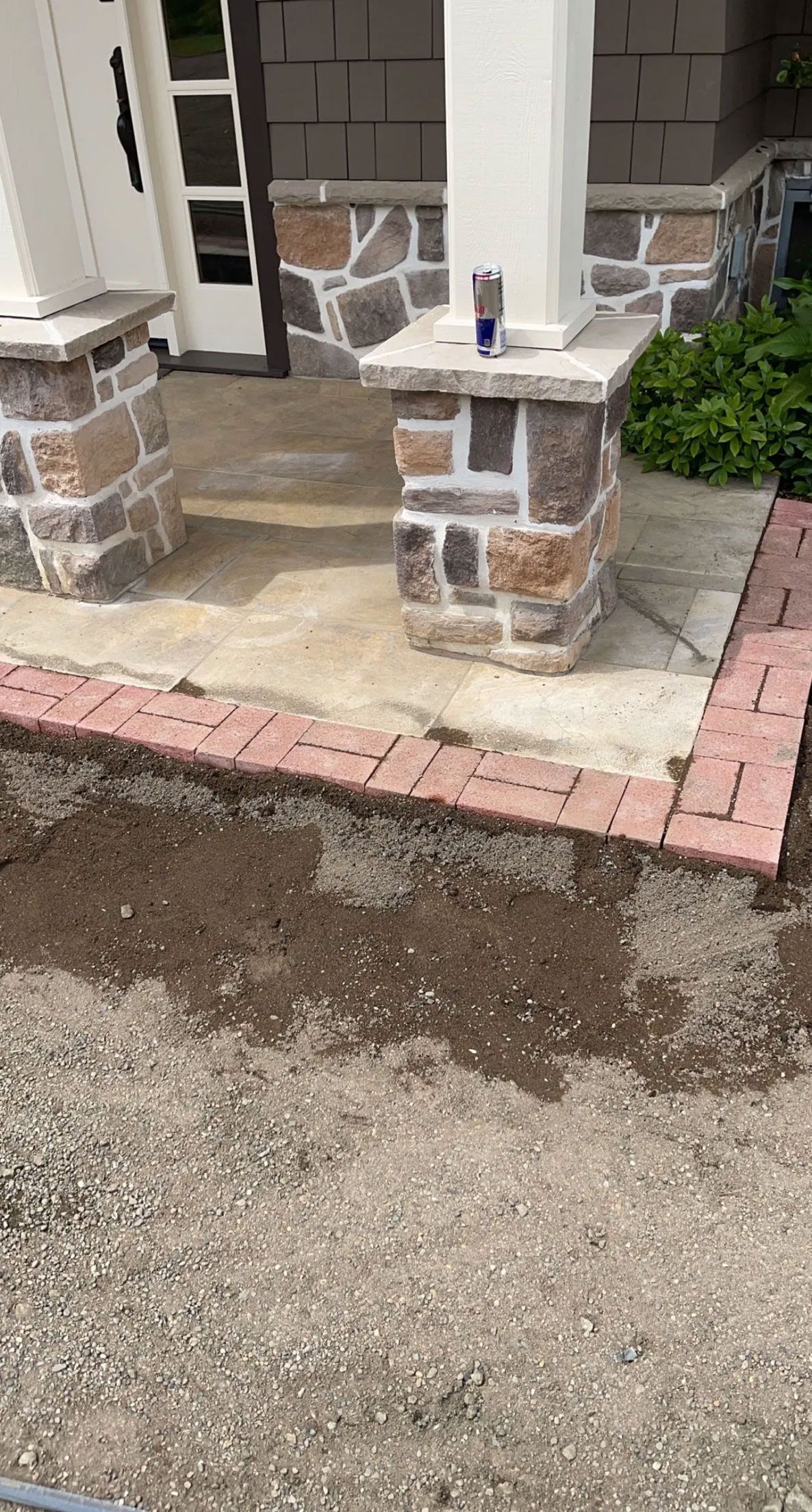 A brick walkway is being built in front of a house.