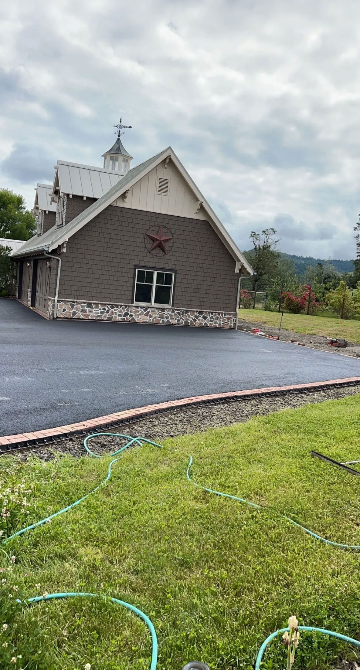 A large house is sitting on top of a lush green hillside.