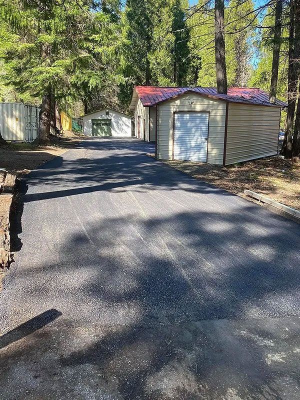 A road with a garage and a shed on the side of it.