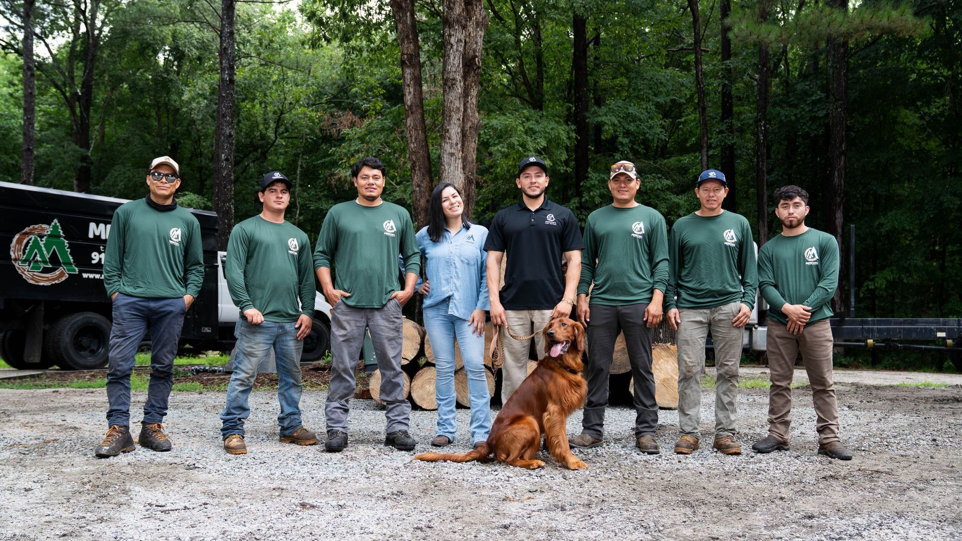 A group of people and a dog are posing for a picture.