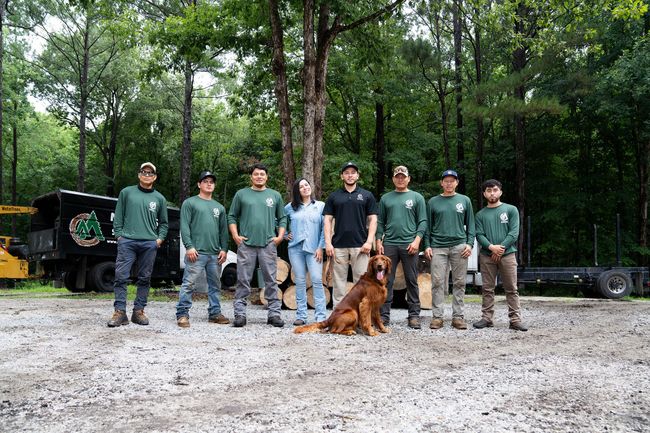 A group of people and a dog are posing for a picture.